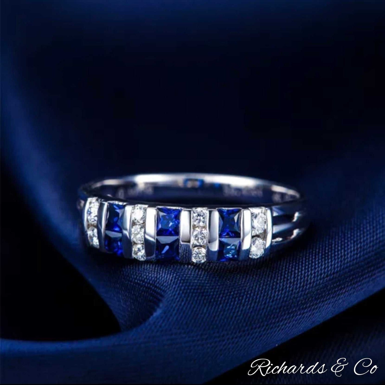 18K white gold sapphire and diamond band ring with princess cut blue sapphires and channel-set diamonds