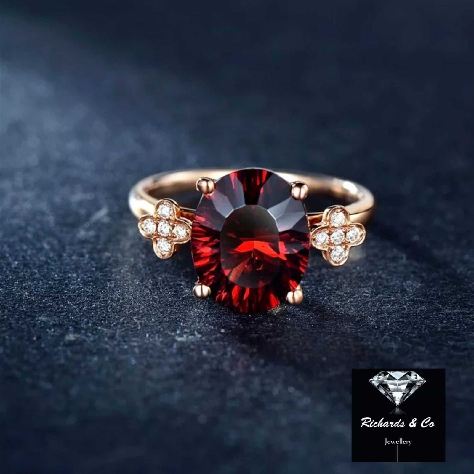 18K rose gold ring with oval rhodolite garnet and white sapphire side stones in four prong setting