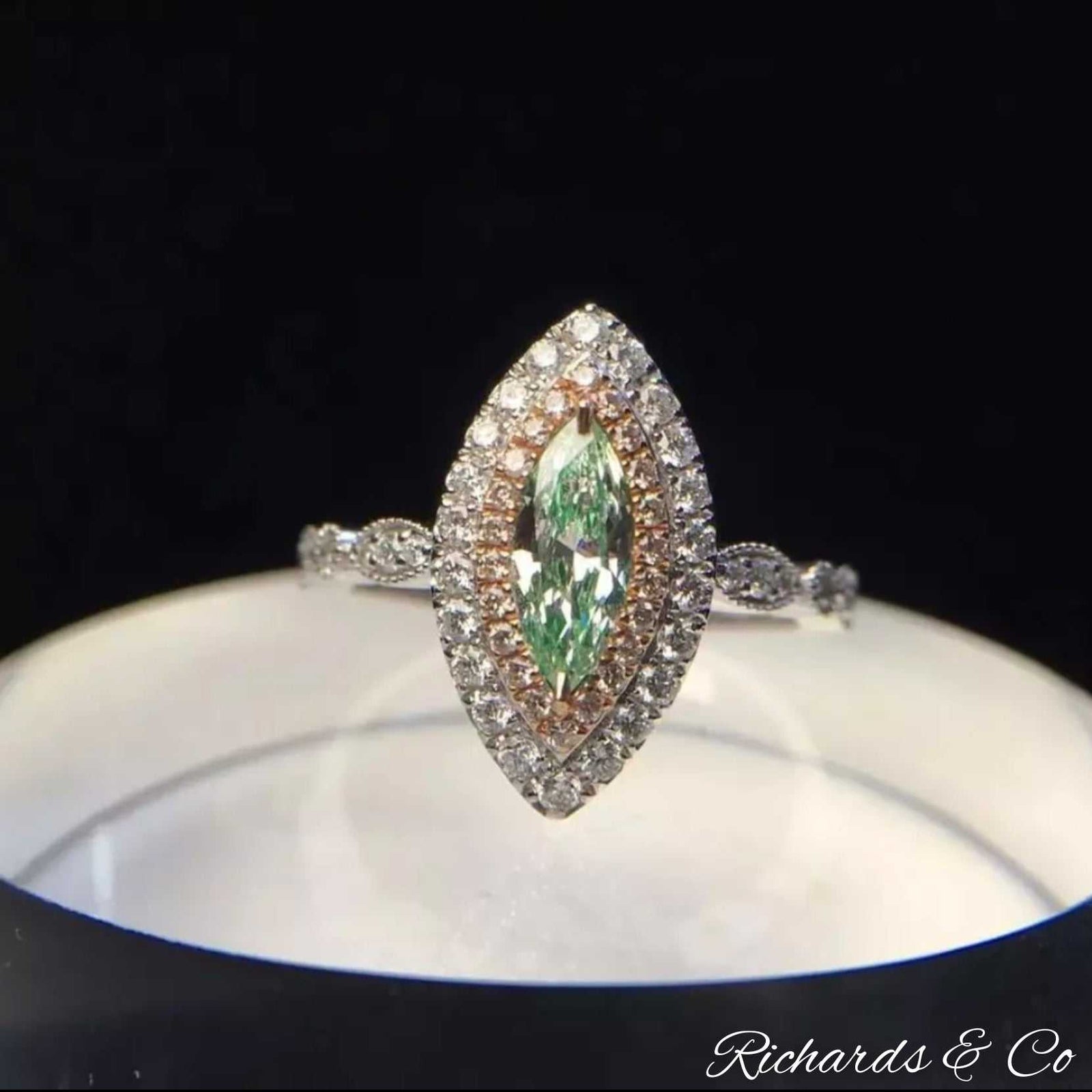 18K white gold ring with rare marquise green diamond center surrounded by small white diamonds with prong setting